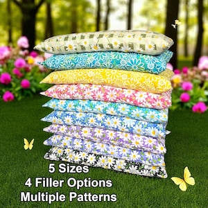 May include: A stack of rectangular pillows featuring various daisy floral patterns in colors including green, teal, yellow, pink, light blue, purple, and black. The text 5 Sizes, 4 Filler Options, Multiple Patterns is printed at the bottom.