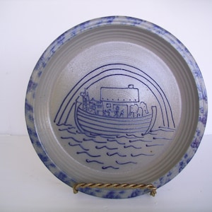 May include: A white ceramic mug with a black handle and the text "But First, Coffee" in a bold, black font. The mug is set against a blurred background, highlighting its clean design.