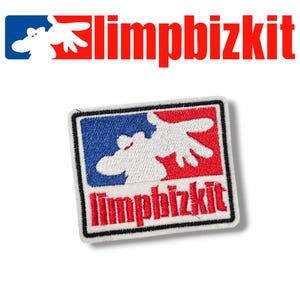 Könnte beinhalten: Weißer gestickter Aufnäher mit einem rot-weiß-blauen Baseball-Logo. Das Logo zeigt ein weißes Elch mit einer roten Hand. Der Text "Limp Bizkit" ist in Weiß unter dem Logo gestickt.