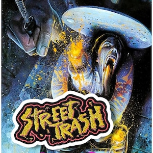 Op de afbeelding: Een zwarte en rode geborduurde patch met de woorden "Street Trash" in gele letters. De patch is geplaatst tegen een achtergrond van een kleurrijk, abstract schilderij met een gezicht van een persoon in het midden.