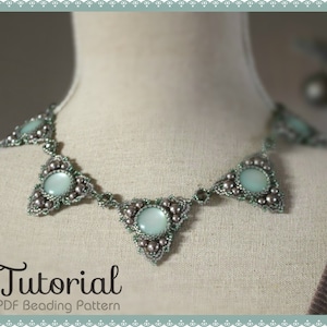 May include: A silver and light blue beaded necklace with a triangular design and a large, round, light blue stone in the center of each triangle. The necklace is on a white mannequin. The text "Tutorial PDF Beading Pattern" is below the necklace.
