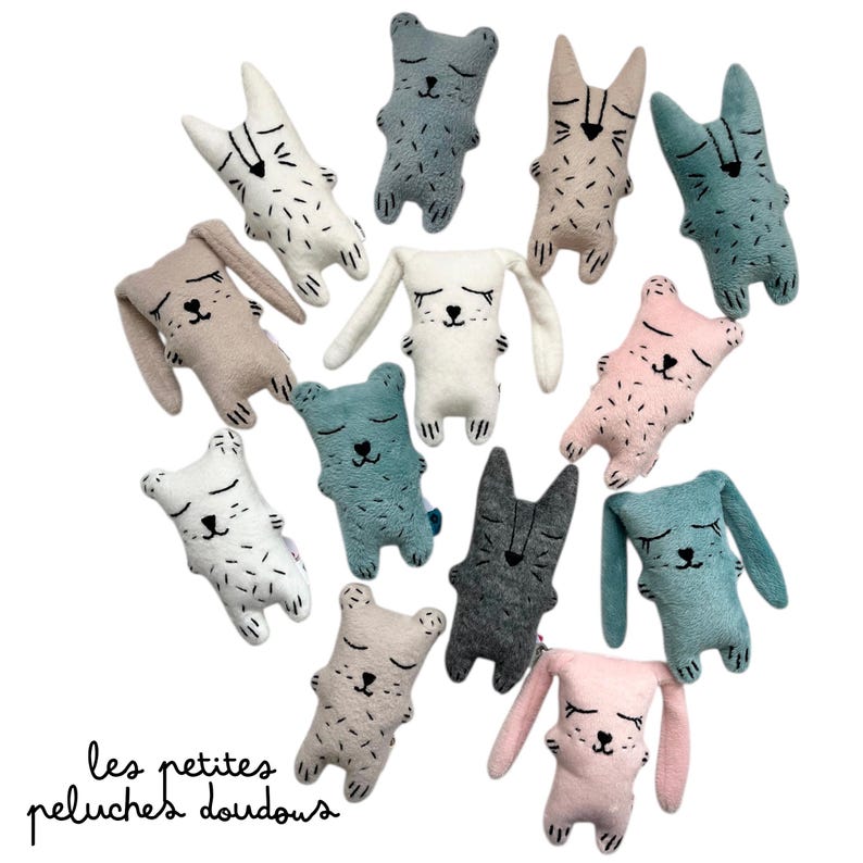 May include: A collection of plush animal toys in various colors, including white, gray, pink, and teal. The toys feature closed eyes and stitched details, with some resembling bears and others rabbits. The text "les petites peluches doudous" is at the bottom.