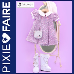 Puede incluir: Un patrón de costura PDF para un vestido de muñeca con estampado floral, cuello blanco y mangas abullonadas. El vestido se combina con botas blancas y un pequeño bolso con forma de gato. El patrón se titula "Pixie Faire" y "Fashioned by Rebecca".