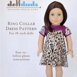 May include: A dollduds pattern for a ring collar dress for 18-inch dolls. The pattern includes easy-to-follow photo instructions. The doll is wearing a brown and white animal print dress with a purple collar.