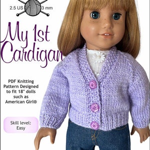 May include: A purple knitted cardigan with buttons, designed to fit 18-inch dolls. The cardigan is being worn by a doll with blonde hair and blue eyes. The text "My 1st Cardigan" is visible in the image. The text "Skill level: Easy" is also visible in the image.
