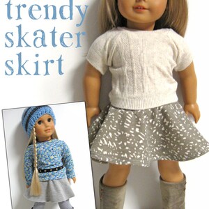 Może przedstawiać: Lalka w szarej sp&oacute;dnicy skater z białym wzorem, białym swetrem i brązowymi butami. Lalka ma blond włosy i niebieskie oczy. Tekst "123 Mulberry Street trendy skater skirt" znajduje się w g&oacute;rnej części obrazu.
