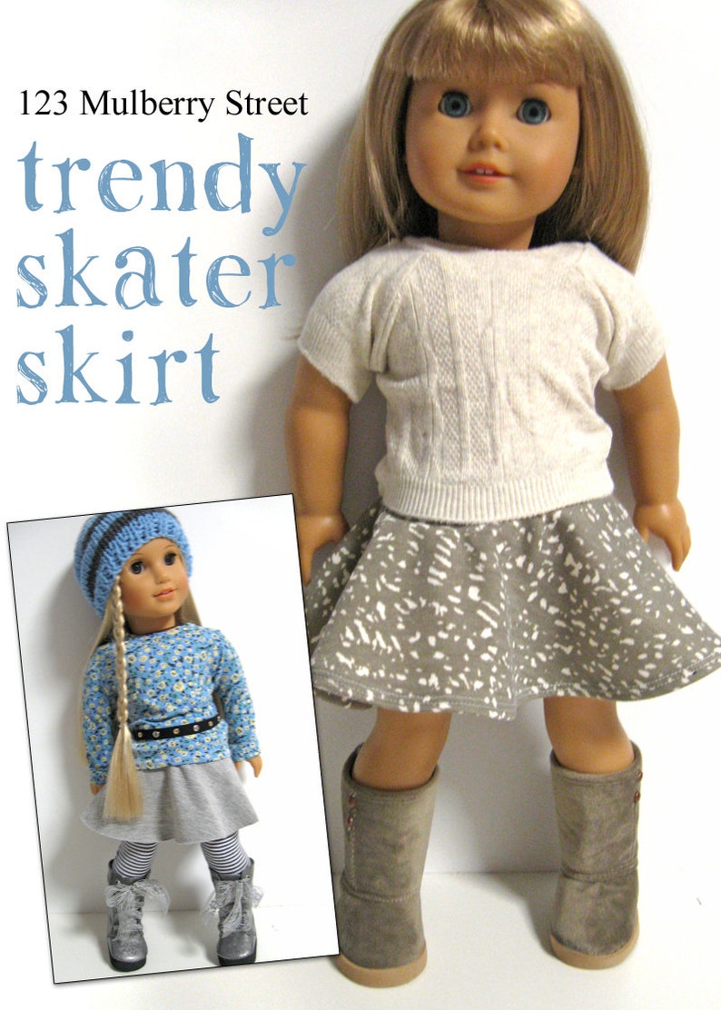Może przedstawiać: Lalka w szarej sp&oacute;dnicy skater z białym wzorem, białym swetrem i brązowymi butami. Lalka ma blond włosy i niebieskie oczy. Tekst "123 Mulberry Street trendy skater skirt" znajduje się w g&oacute;rnej części obrazu.