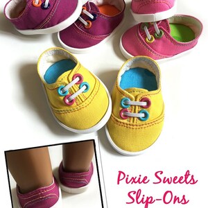 May include: A set of four colorful slip-on shoes designed to fit 18-inch American Girl&reg; dolls. The shoes are made of fabric and have a white sole. The shoes are pink, yellow, and have a variety of colorful laces. "Pixie Sweets Slip-Ons" is written in pink text on a white background.