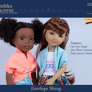 May include: Two dolls wearing different outfits. The doll on the left is wearing a coral colored shrug over a blue and white patterned dress. The doll on the right is wearing a light blue shrug over a white shirt with the words "Read Big" on it and a colorful skirt. The dolls are both looking at the camera. The image is titled "Envelope Shrug" and has the text "Features: One Piece Design Zero-Waste Construction Fully Lined or Unlined Options" below the dolls.