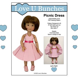 May include: A doll wearing a pink and white gingham picnic dress with a pink belt and matching shoes. The image includes the text "Love U Bunches" and "Picnic Dress". A smaller image shows the doll twirling.