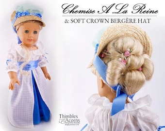 May include: A doll wearing a white and blue dress with a blue sash and a straw hat with a blue ribbon. The doll is wearing a hairstyle with pink flowers and pearls. The text "Chemise A La Reine & SOFT CROWN BERGERE HAT" is above the doll.