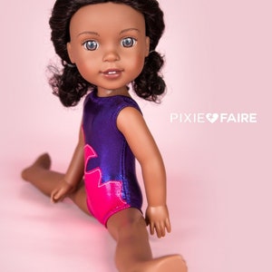 Puede incluir: Una mu&ntilde;eca de piel morena con ojos azules y cabello casta&ntilde;o oscuro lleva un leotardo morado y rosa. La mu&ntilde;eca est&aacute; sentada en posici&oacute;n de split con las piernas extendidas hacia los lados. El fondo es de color rosa claro.