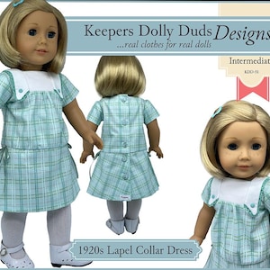 May include: Three dolls wearing a light blue plaid dress with a white lapel collar. The dress has short sleeves and a pleated skirt. The text "Keepers Dolly Duds Designs" and "1920s Lapel Collar Dress" are visible.