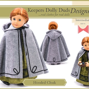 Può includere: Un mantello grigio con cappuccio e bordi neri per una bambola. Il mantello ha un cappuccio ed è fatto di un tessuto morbido e peloso. La bambola indossa un vestito verde sotto il mantello. Il modello è intitolato "Hooded Cloak" ed è etichettato come "Intermedio" e "KDD-41".