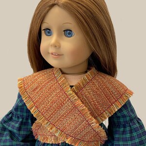 May include: A doll with long brown hair and blue eyes wearing a green plaid dress with a brown and orange fringed shawl. The doll's name is Flossie Potter.
