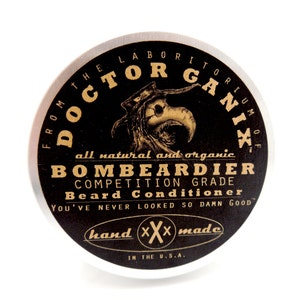 May include: A silver tin with a black label that reads "From the Laboratorium of Doctor Ganix" and "All natural and organic Bombeardier Competition Grade Beard Conditioner". The label also says "You've never looked so damn good" and "Hand XXX Made in the U.S.A."