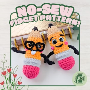 May include: Two handmade crochet pencil-shaped fidget toys. One pencil wears glasses. The pencils are orange, tan, grey, pink, and black. The image includes the text "NO-SEW FIDGET PATTERN!"