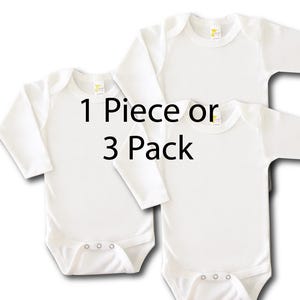 May include: Two white long-sleeve baby onesies, one on top of the other. The onesies have snaps at the bottom. The text "1 Piece or 3 Pack" is printed in black on the onesies.