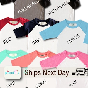 May include: A collection of raglan baseball style t-shirts in various colors, including red, navy, light blue, mint, coral, and pink. Each shirt has a white body and contrasting sleeves. The text "Ships Next Day" is also visible.