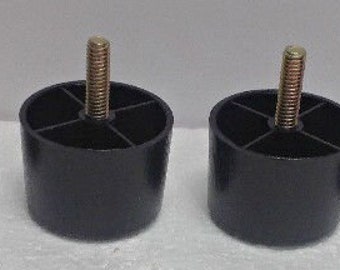 May include: Four black plastic furniture leg risers with a threaded screw top. Each riser has four grooves around the base.