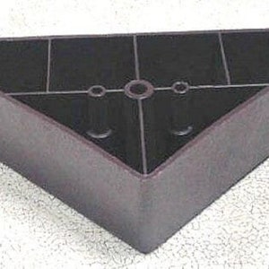 May include: A dark brown plastic furniture leg with a triangular shape and three holes in the center.
