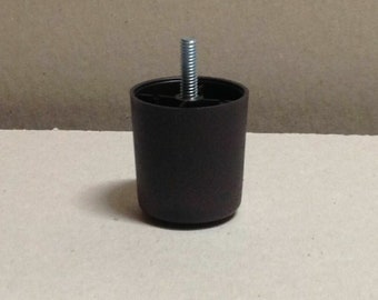 May include: A dark brown plastic furniture leg with a threaded metal screw. The leg is designed to be attached to furniture to raise it off the ground.