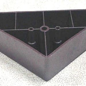 May include: A dark brown triangular furniture leg with three holes in the top. The leg is made of plastic and has a smooth surface.