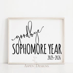 Könnte beinhalten: Ein gerahmtes weißes Schild mit den Worten "goodbye SOPHOMORE YEAR 2025-2026" in schwarzer Schrift und Blockbuchstaben. Das Schild befindet sich in einem hellfarbigen Holzrahmen. Die Worte "Aspen Designs" stehen unten.