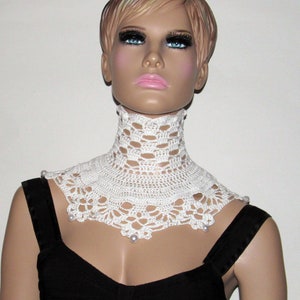Puede incluir: Collar blanco de ganchillo con detalles de perlas. El collar es un dise&ntilde;o delicado e intrincado, perfecto para a&ntilde;adir un toque de elegancia a cualquier atuendo.