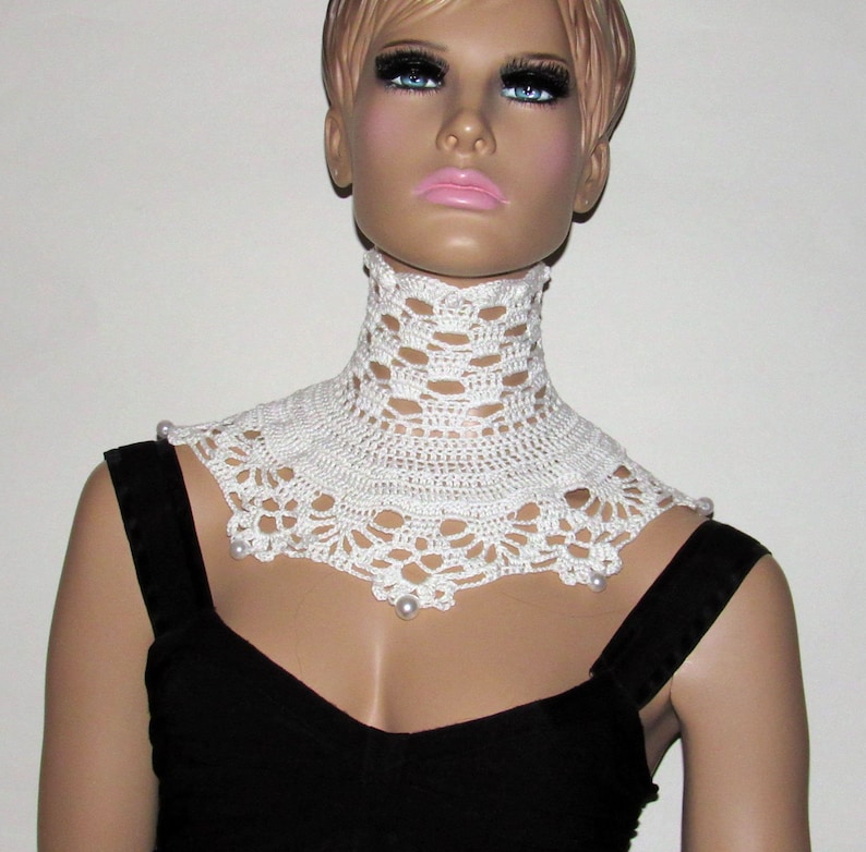 Puede incluir: Collar blanco de ganchillo con detalles de perlas. El collar es un dise&ntilde;o amplio y abierto con un delicado patr&oacute;n de encaje.