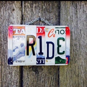 License plate art. Skier. Ride. License plate. Sign. Cabin. Ski. Snow. Mountain. Ski lodge. Skiing. Cabin decor. Sled. Sleigh