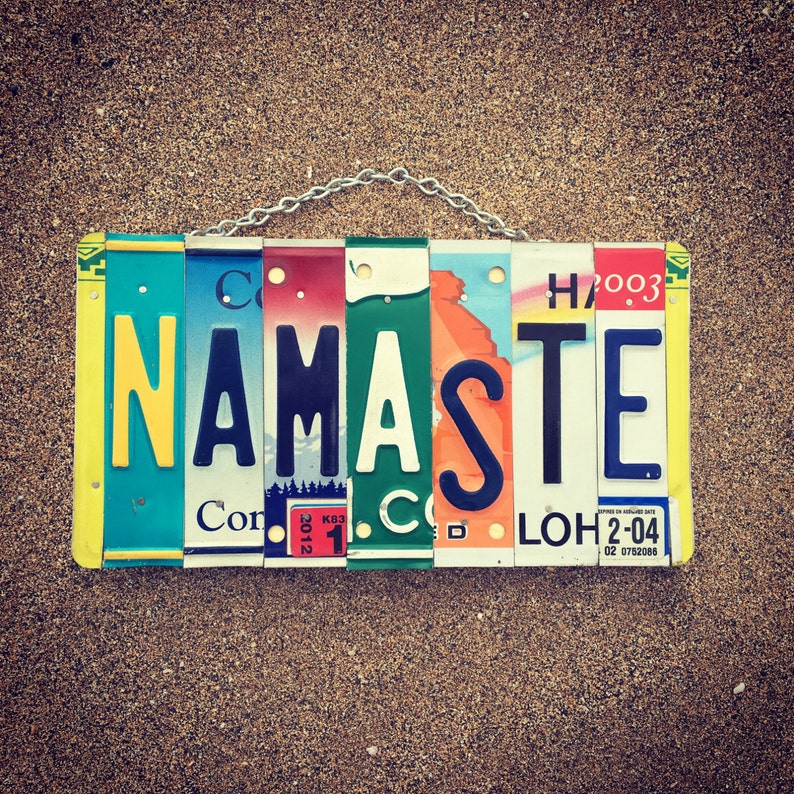 May include: A colorful sign made from license plates spelling out the word "Namaste".