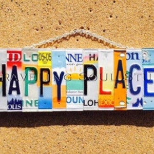 May include: A sign made of licence plates spelling out "HAPPY PLACE" in black letters. The licence plates are various colours and have different state abbreviations and numbers.