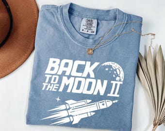 Koszulka z motywem „Back to the Moon” | Koszulka retro z motywem kosmicznym | Grafika vintage z rakietą | Minimalistyczna koszulka w stylu kosmicznym | Koszulka unisex z motywem startu księżyca
