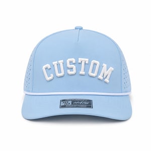 Puede incluir: Gorra de b&eacute;isbol azul claro con la palabra "CUSTOM" en letras blancas en relieve. La gorra tiene un detalle de cuerda blanca a lo largo del borde y peque&ntilde;os orificios de ventilaci&oacute;n. La etiqueta dice "10/10 HATS WATERPROOF".
