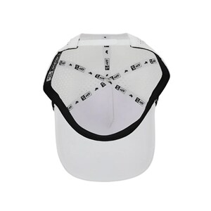 K&ouml;nnte beinhalten: Wei&szlig;e Baseballkappe mit gebogenem Schirm und schwarzem Rand. Das Innere hat ein atmungsaktives Mesh-Design und ein schwarzes Band. Die Kappe hat eine strukturierte Krone und einen vorgekr&uuml;mmten Schirm.