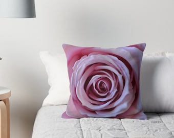 May include: A close-up of a pink rose with a soft, velvety texture. The rose is in focus, while the background is blurred.