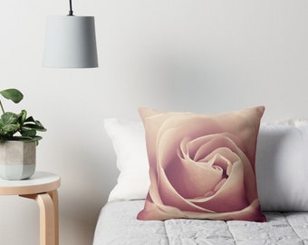 May include: A close-up of a soft, pale pink rose with a delicate, layered center. The rose is in focus, while the background is blurred, creating a soft, romantic feel.