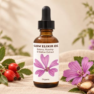 May include: An amber glass dropper bottle labeled Glow Elixir Oil with Batana, Rosehip, and Mallow Extract. The white label features a purple mallow flower illustration and the word Organic. The bottle has a black dropper cap and contains oil.