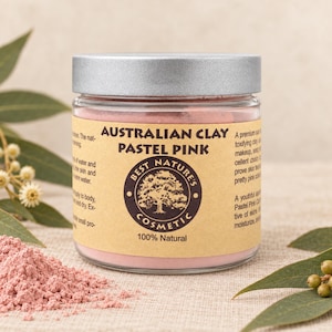 Puede incluir: Un frasco de vidrio transparente con tapa plateada que contiene polvo de arcilla australiana rosa pastel. La etiqueta beige presenta el texto "AUSTRALIAN CLAY PASTEL PINK" y "BEST NATURE'S COSMETIC 100% Natural" con un logotipo de árbol circular.