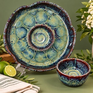 May include: A ceramic serving platter with a central circular compartment and a matching separate bowl. Both pieces feature a reactive glaze with a deep blue and dark brown rim, transitioning into a light green, honeycomb-patterned center.