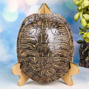 May include: A set of three ceramic mugs with a speckled, matte finish. The mugs are in shades of cream, light gray, and dark gray. Each mug has a simple, minimalist design and a rounded handle.