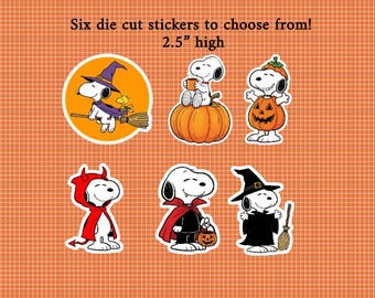May include: Six die cut stickers featuring Snoopy in various Halloween costumes, including a witch, a pumpkin, a devil, and a vampire. Each sticker is 6.35 cm high. The designs include Snoopy with Woodstock, holding a mug, and carrying a pumpkin bucket.