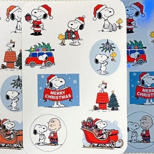 May include: Sheet of Christmas stickers featuring Snoopy in festive scenes. Snoopy is shown wearing a Santa hat, carrying gifts, and with Charlie Brown. Designs include a red sleigh, a Christmas tree, and the text "Merry Christmas."