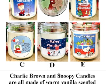 May include: A selection of Charlie Brown and Snoopy Christmas candles in glass jars. Each candle has a different label with holiday graphics and text. The candles are made of vanilla-scented soy wax and include mini-wax melts and sprinkles. Black lids are included.