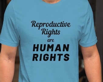 May include: A light blue t-shirt with the text "Reproductive Rights are HUMAN RIGHTS" printed in black.