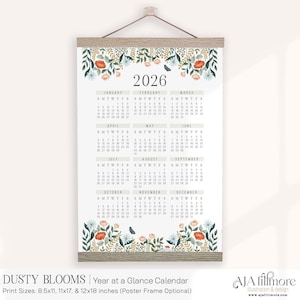 May include: A 2026 year-at-a-glance calendar with a floral design. The calendar is printed on a white background and features a wooden frame at the top and bottom. The floral design includes orange, green, and blue flowers. The calendar is 8.5x11 inches.