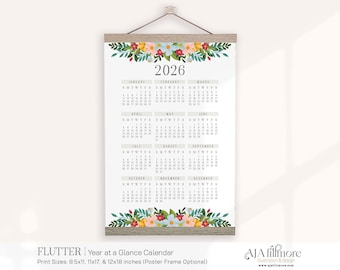 May include: A 2026 year-at-a-glance calendar with a floral design. The calendar is printed on a white background and features a wooden frame. The top and bottom of the calendar are decorated with colorful flowers and green leaves.