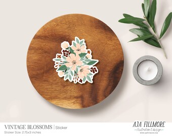 May include: A sticker featuring a vintage floral bouquet with peach, white, and green flowers, brown berries, and green leaves. The sticker is on a wooden surface. "Vintage Blossoms | Sticker" and "Sticker Size: 2.75x3 inches" are printed below the sticker.