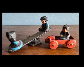 Cast iron Amish seesaw and girl in wagon toys.